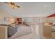 Open-concept living room with a fireplace, carpeted floors, and seamless access to the kitchen area at 12229 W Berry Ave, Littleton, CO 80127