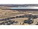 An aerial view of a community near a lake and dam, with well-maintained homes, roads and a green space at 15753 E Indian Brook Cir, Parker, CO 80134