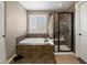 Bathroom featuring a glass-doored shower, a soaking tub, tile accents, and plenty of natural light at 15753 E Indian Brook Cir, Parker, CO 80134