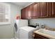 Laundry room with modern washer and dryer, storage cabinets, and a utility sink at 15753 E Indian Brook Cir, Parker, CO 80134