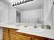 Bright bathroom with a large mirror, white countertop, and wooden vanity at 9700 E Iliff Ave # D44, Denver, CO 80231