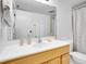 Bathroom with a white sink, bright lighting, a large mirror, and white tile in the shower at 9700 E Iliff Ave # D44, Denver, CO 80231