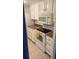 Kitchen featuring white appliances, tile flooring, and honey colored countertops at 9700 E Iliff Ave # D44, Denver, CO 80231
