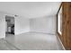 Bright living room featuring wood paneling and view to the kitchen area at 9700 E Iliff Ave # D44, Denver, CO 80231