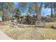 Community outdoor space with rock feature, seating and mature trees at 9700 E Iliff Ave # D44, Denver, CO 80231