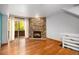 Bright living room featuring a cozy stone fireplace, hardwood floors, and a sliding glass door at 718 Julian Cir, Lafayette, CO 80026