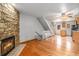 Open-concept living area with stone fireplace, hardwood floors, and staircase at 718 Julian Cir, Lafayette, CO 80026