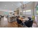 Modern kitchen with a large island, hardwood floors, stainless steel appliances, open to dining area with stylish chandelier at 756 Dreamcatcher Ln, Evergreen, CO 80439