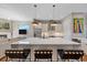 Bright kitchen with large island, modern lighting, stainless steel appliances, and view into the living room at 756 Dreamcatcher Ln, Evergreen, CO 80439