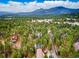 Aerial view showing the property's location amongst a dense forest and mountains in the background at 28254 Tresine Dr, Evergreen, CO 80439