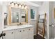 Bright bathroom featuring a wood framed mirror, towels on a ladder, and a white vanity at 28254 Tresine Dr, Evergreen, CO 80439
