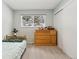 Well-lit bedroom featuring neutral carpet, a dresser, and a bright window at 28254 Tresine Dr, Evergreen, CO 80439
