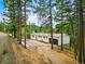 A serene home nestled among tall trees, with a long driveway and an attached garage at 28254 Tresine Dr, Evergreen, CO 80439