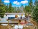 Rear exterior of home showing deck with outdoor furniture and beautiful wooded view at 28254 Tresine Dr, Evergreen, CO 80439
