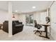Basement living room space with comfortable seating, workspace, and sliding glass doors to the outdoors at 28254 Tresine Dr, Evergreen, CO 80439