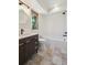 Bathroom featuring a dark wood vanity, modern fixtures, and tiled shower at 1321 W Caley Ave, Littleton, CO 80120