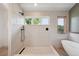 This modern bathroom features a glass shower with black fixtures and a soaking tub at 1321 W Caley Ave, Littleton, CO 80120