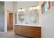 Bright bathroom featuring a dual sink vanity, modern lighting, and wood accents at 1321 W Caley Ave, Littleton, CO 80120