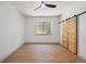 Bedroom featuring hardwood floors, large windows, and a barn door closet at 1321 W Caley Ave, Littleton, CO 80120
