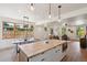 Spacious kitchen and dining area with hardwood floors, island seating, and modern lighting at 1321 W Caley Ave, Littleton, CO 80120
