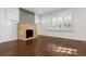 Bright living room with a stone fireplace and gleaming hardwood floors, illuminated by natural light at 2033 E 21St Ave, Denver, CO 80205