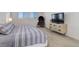 Bedroom featuring a comfortable bed, modern dresser with TV, and a stylish chair beside shuttered windows at 14077 Yellow Tip Drive, Parker, CO 80134