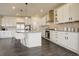 Gourmet kitchen featuring white cabinets, a center island with barstools, and modern lighting at 14077 Yellow Tip Drive, Parker, CO 80134
