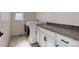 A laundry room with white cabinets, gray countertops and a modern washer and dryer set at 14077 Yellow Tip Drive, Parker, CO 80134