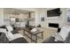 Open concept living room with fireplace, sleek furniture, and modern kitchen view at 14077 Yellow Tip Drive, Parker, CO 80134