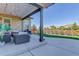 Covered patio with outdoor seating overlooking the manicured lawn and landscaping at 14077 Yellow Tip Drive, Parker, CO 80134