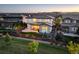 Well-lit rear of house with patio, fenced yard, professional landscaping, and mountain view in the background at 14077 Yellow Tip Drive, Parker, CO 80134