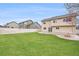 A beautiful and expansive backyard featuring lush green grass, a concrete patio, and a charming fire pit area at 5210 Roadrunner Ave, Firestone, CO 80504