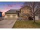 Charming two-story home with a well-manicured lawn, attached two car garage, stone accents, and inviting front entrance at 5210 Roadrunner Ave, Firestone, CO 80504