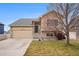 Charming two-story home with a well-manicured lawn, two car garage, and a stone and siding exterior at 5210 Roadrunner Ave, Firestone, CO 80504