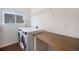 Convenient laundry room with a washer, dryer, storage shelf, and countertop folding area at 5210 Roadrunner Ave, Firestone, CO 80504