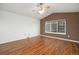 Bright living room with a ceiling fan and large window illuminating the beautiful hardwood floors at 5210 Roadrunner Ave, Firestone, CO 80504