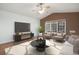 Bright living room featuring a ceiling fan, large window, modern furnishings, and a flat-screen TV at 5210 Roadrunner Ave, Firestone, CO 80504