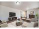 Spacious living room boasts a large flat-screen TV, stylish seating, and a modern coffee table for relaxation at 5210 Roadrunner Ave, Firestone, CO 80504