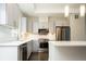 Modern kitchen featuring stainless steel appliances, stylish gray cabinets, white countertops, and attractive lighting at 2858 W Parkside Pl, Denver, CO 80221