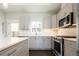 Modern kitchen featuring stainless steel appliances, stone countertops, grey cabinets, and hardwood floors at 2858 W Parkside Pl, Denver, CO 80221