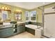 Vintage bathroom with dual vanity sinks, garden tub, and a glass-enclosed shower at 9682 Hemlock Ct, Highlands Ranch, CO 80130