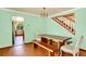 Bright dining room with wooden table and chairs, and a view of the staircase at 9682 Hemlock Ct, Highlands Ranch, CO 80130