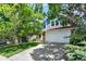 Beautiful blue home with a spacious driveway, mature trees, and a welcoming front lawn at 9682 Hemlock Ct, Highlands Ranch, CO 80130