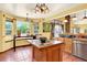 Sunlit kitchen boasts large windows, brick detail, and a central island for food preparation at 9682 Hemlock Ct, Highlands Ranch, CO 80130