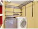 Bright laundry room with front-load washer and dryer units plus shelving at 9682 Hemlock Ct, Highlands Ranch, CO 80130