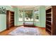 Cozy living room featuring large windows, hardwood floors, and custom built-in bookcases at 9682 Hemlock Ct, Highlands Ranch, CO 80130