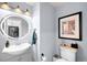 Stylish powder room with modern lighting, decorative mirror, and sleek fixtures at 13706 Legend Trail # 104, Broomfield, CO 80023