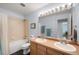 Bright bathroom featuring double sinks, a bathtub with shower, and natural light at 13706 Legend Trail # 104, Broomfield, CO 80023