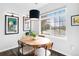 Bright dining area with a round wooden table, pendant lighting, and natural light at 13706 Legend Trail # 104, Broomfield, CO 80023