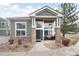 Charming home with green siding, stone accents, and large windows providing ample natural light at 13706 Legend Trail # 104, Broomfield, CO 80023